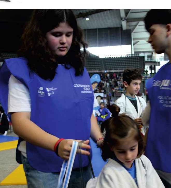 Voluntarios de tatami del Trofeo Miguelito acompañando a un judoka